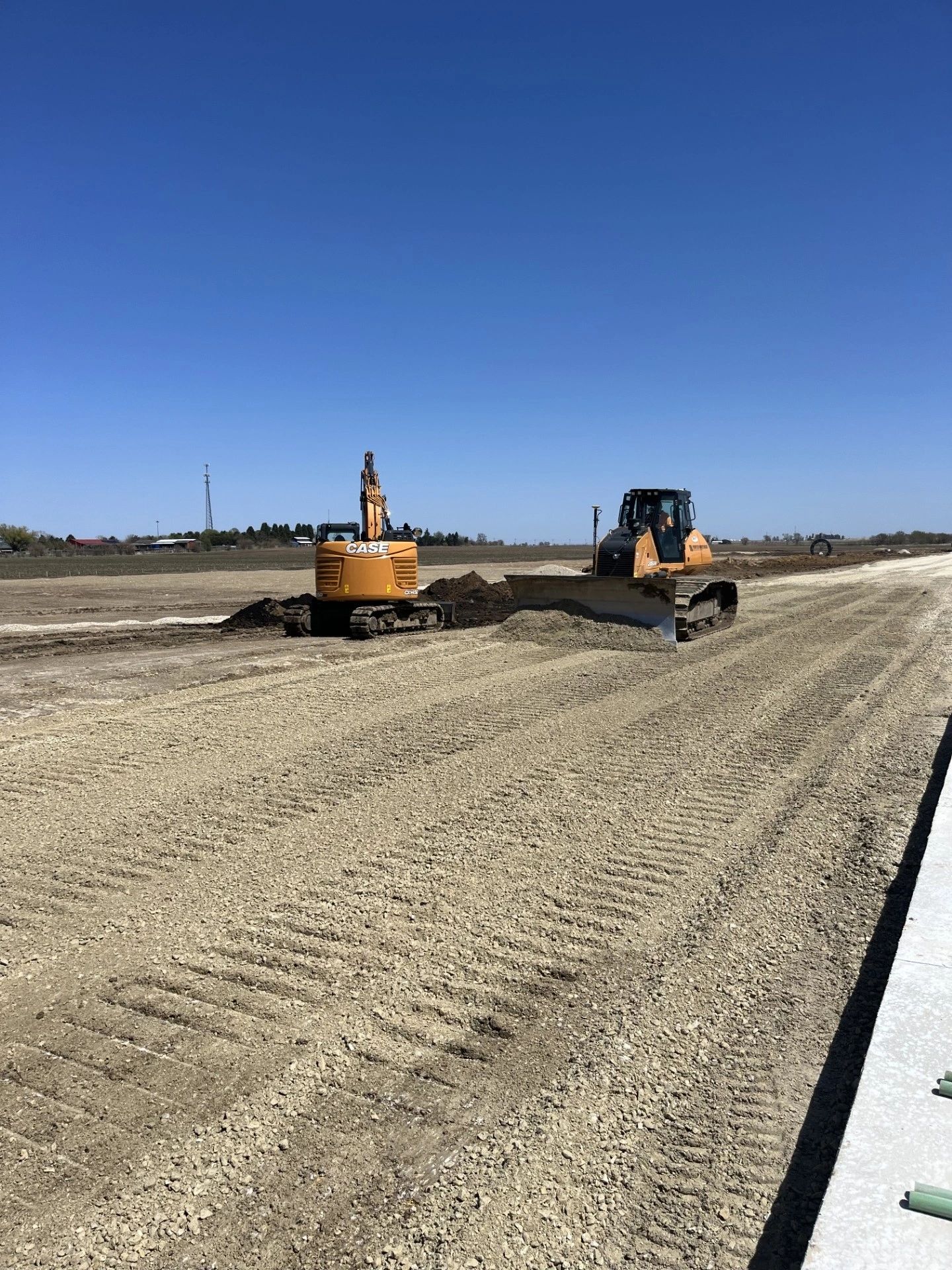 Excavation and grading equipment preparing an asphalt base