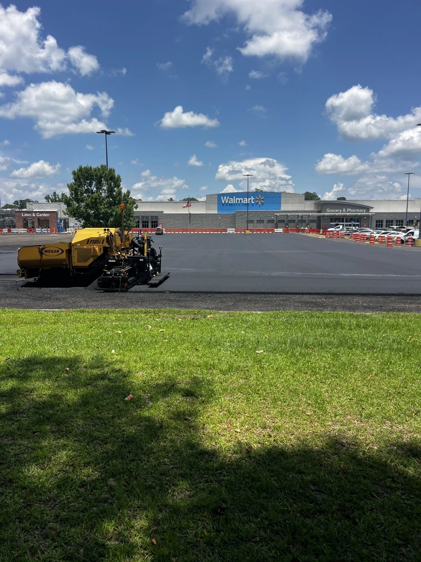 Paving equipment resurfacing a commercial parking lot